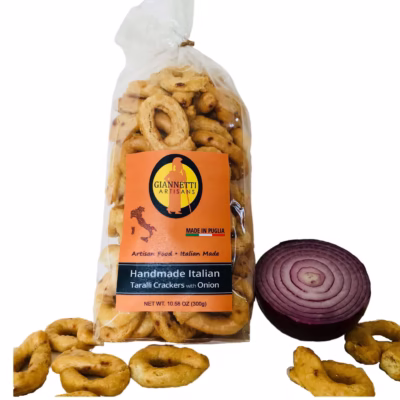 Close up of a bag of Giannetti Artisans imported onion taralli crackers with a red onion prop on a white background