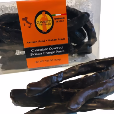 Side angle of a 7.05 oz box of Giannetti Artisans chocolate orange peels with a few peels on the side of the box for demonstrative purposes