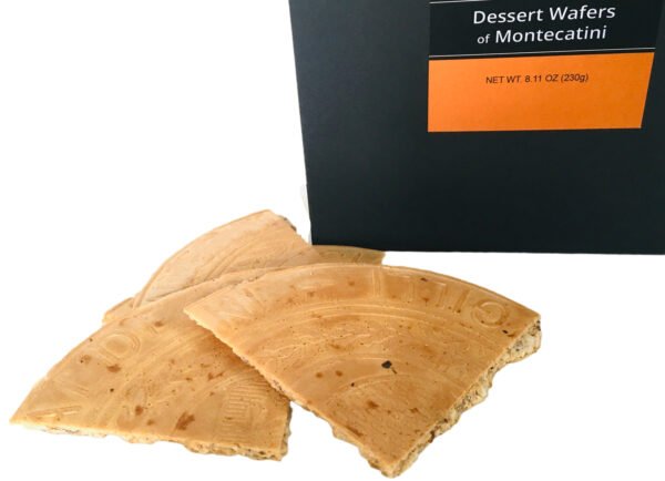 Close up of Giannetti Artisans montecatini wafer pieces with a partial view of the black packaging  on a white background