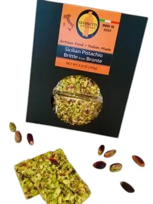 Black package of Giannetti Artisans Sicilian Pistachio Brittle with a piece of brittle and loose pistachios in front.