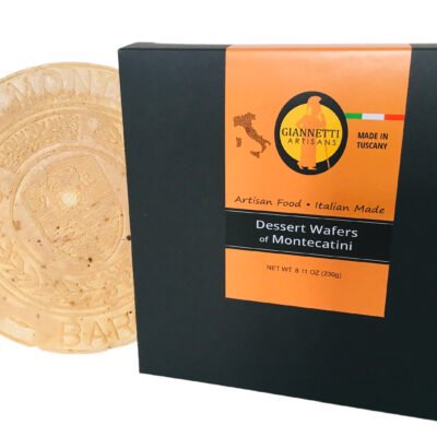 A black packaging box of Giannetti Artisans montecatini wafers and a one wafer sitting next to the box as prop on a white background